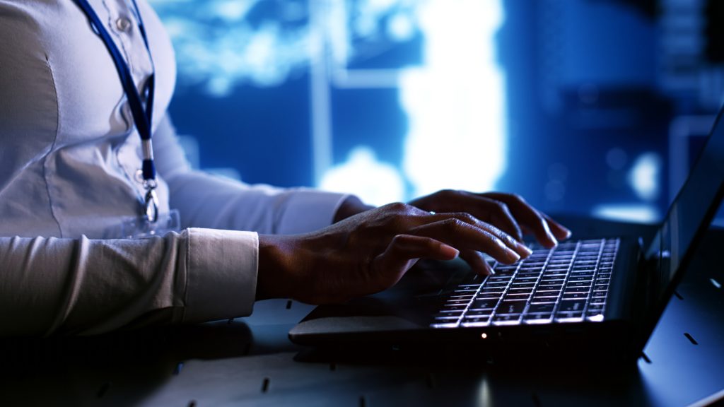 Gros plan de mains tapant sur un clavier d'ordinateur